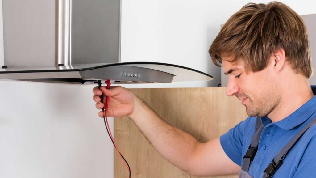 Technician inspecting kitchen exhaust hood ventilation system