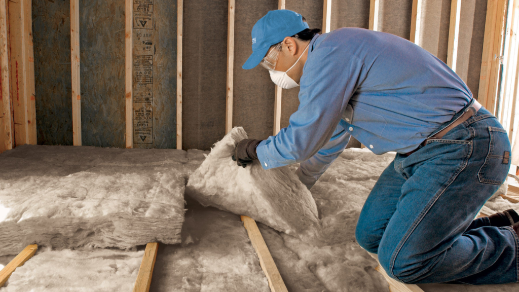 Technician installing attic insulation in residential home