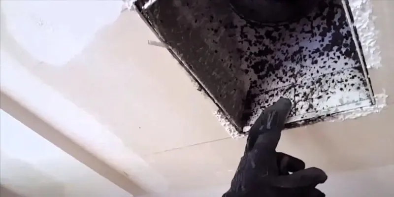 Technician inspecting dirty HVAC air vent with dust buildup